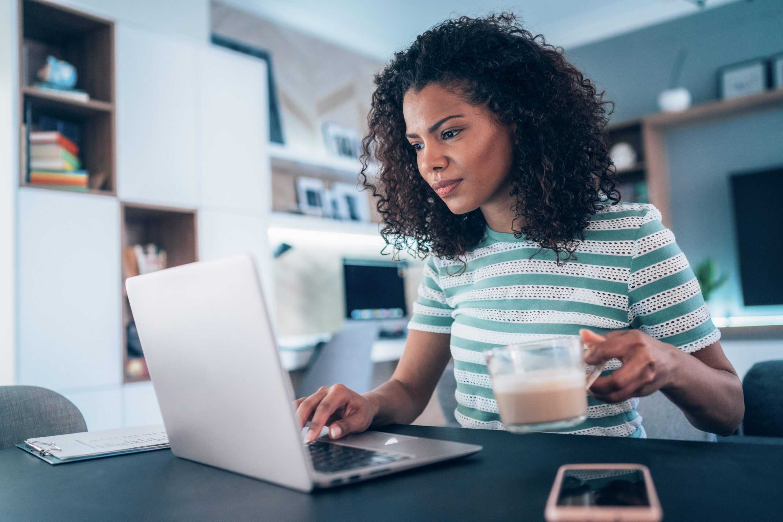 Young modern woman working from home, using laptop